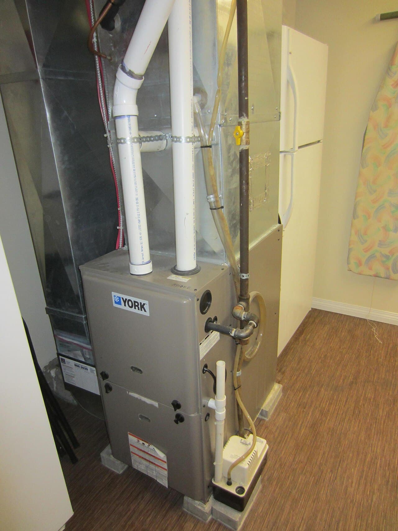 American-style upright condensing gas furnace installed in a residential utility closet