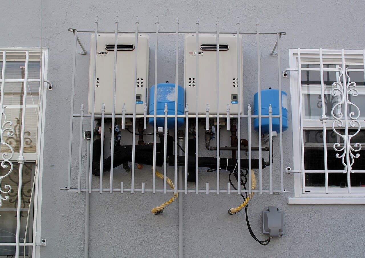 Two wall-mounted Noritz tankless water heaters installed with piping and gas lines